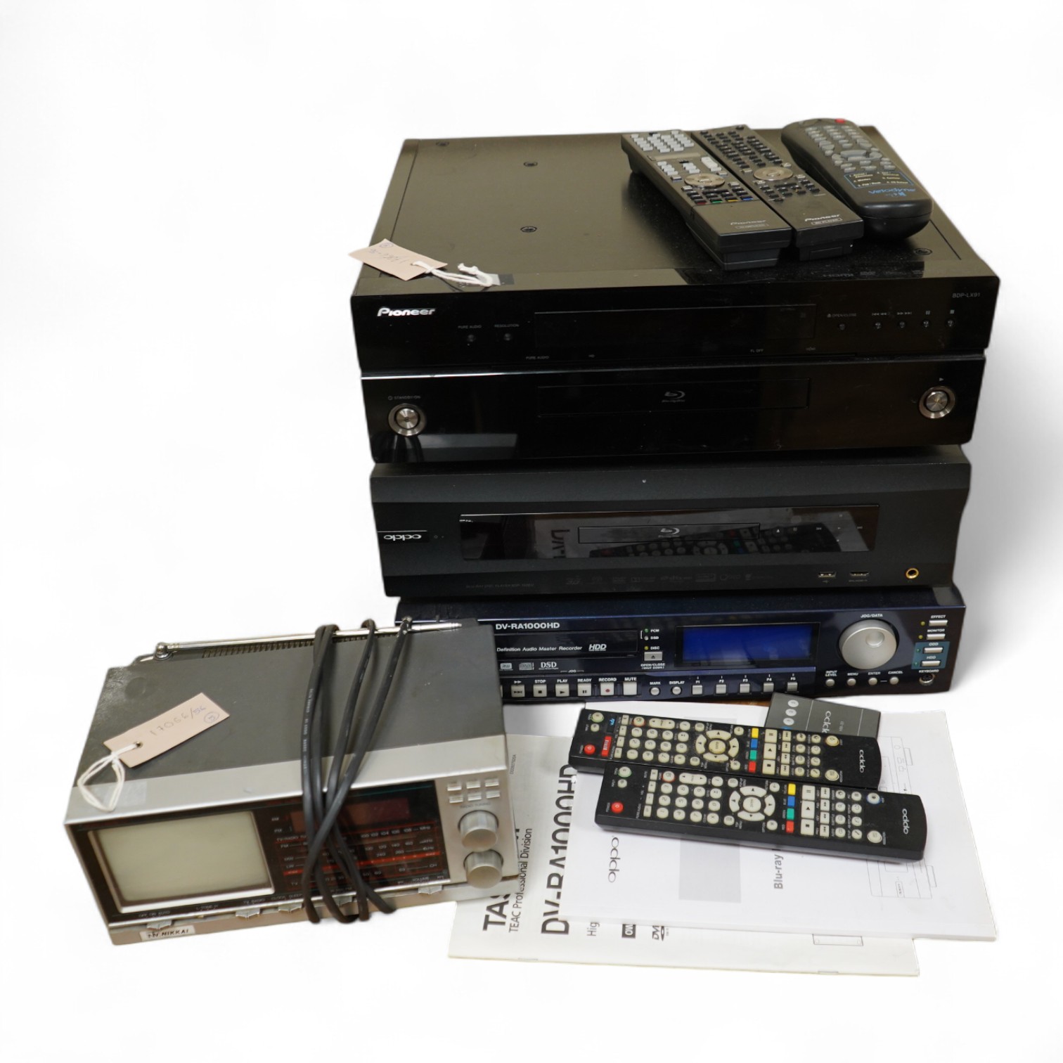 Three Blu-ray/DVD players including; an OPPO BDP-105EU Blu-ray player with user manual and remote control, a Pioneer BDP-LX91 Blu-ray player with remote control, and a Tascam DV-RA1000HD DVD player with owners manual, bu